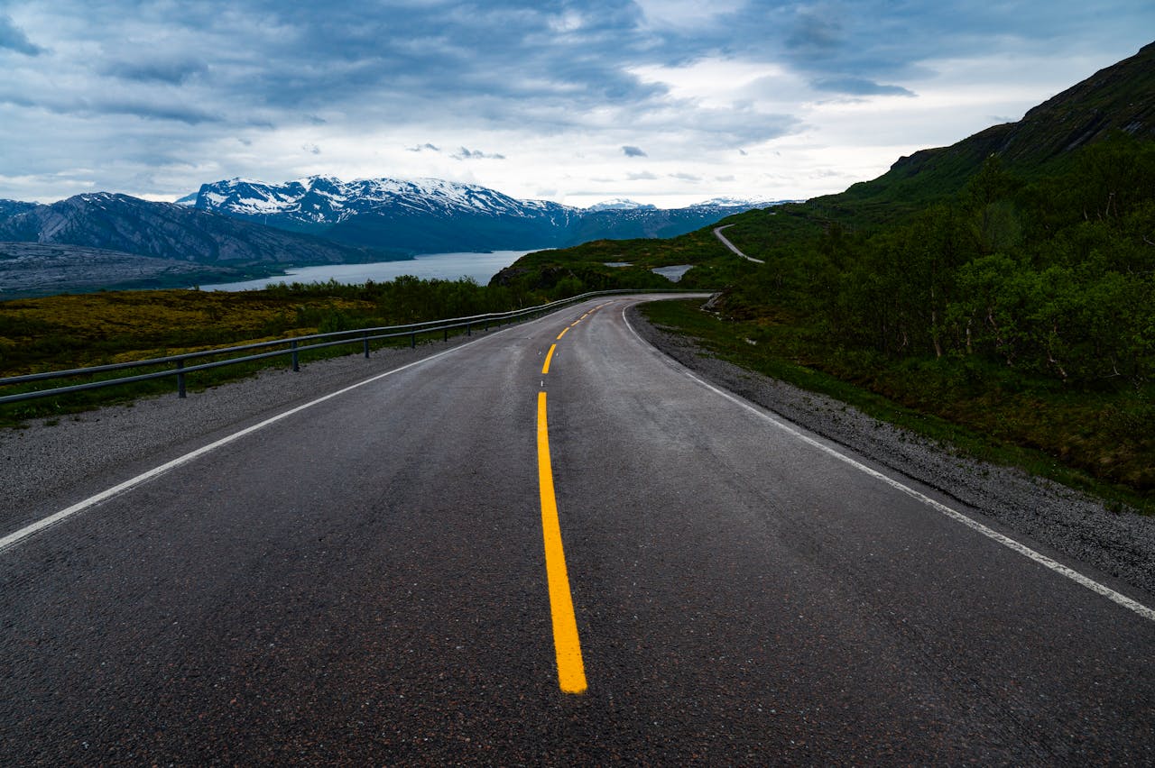 Quiet road winding through Norway's stunning mountains, offering tranquil and picturesque scenery.